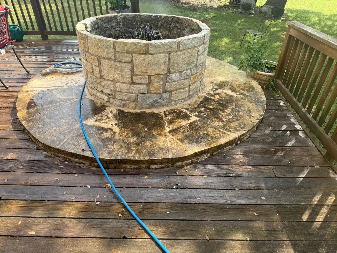 Fire-pit patio before cleaning with dark surface buildup