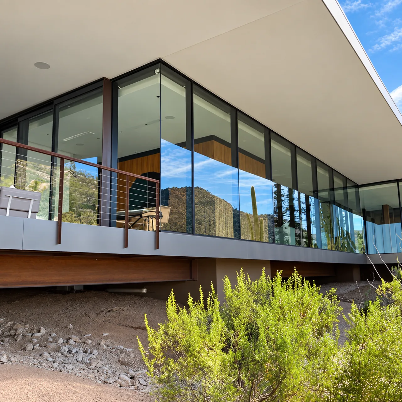 Wraparound glass beneath a modern home's deep roof overhang